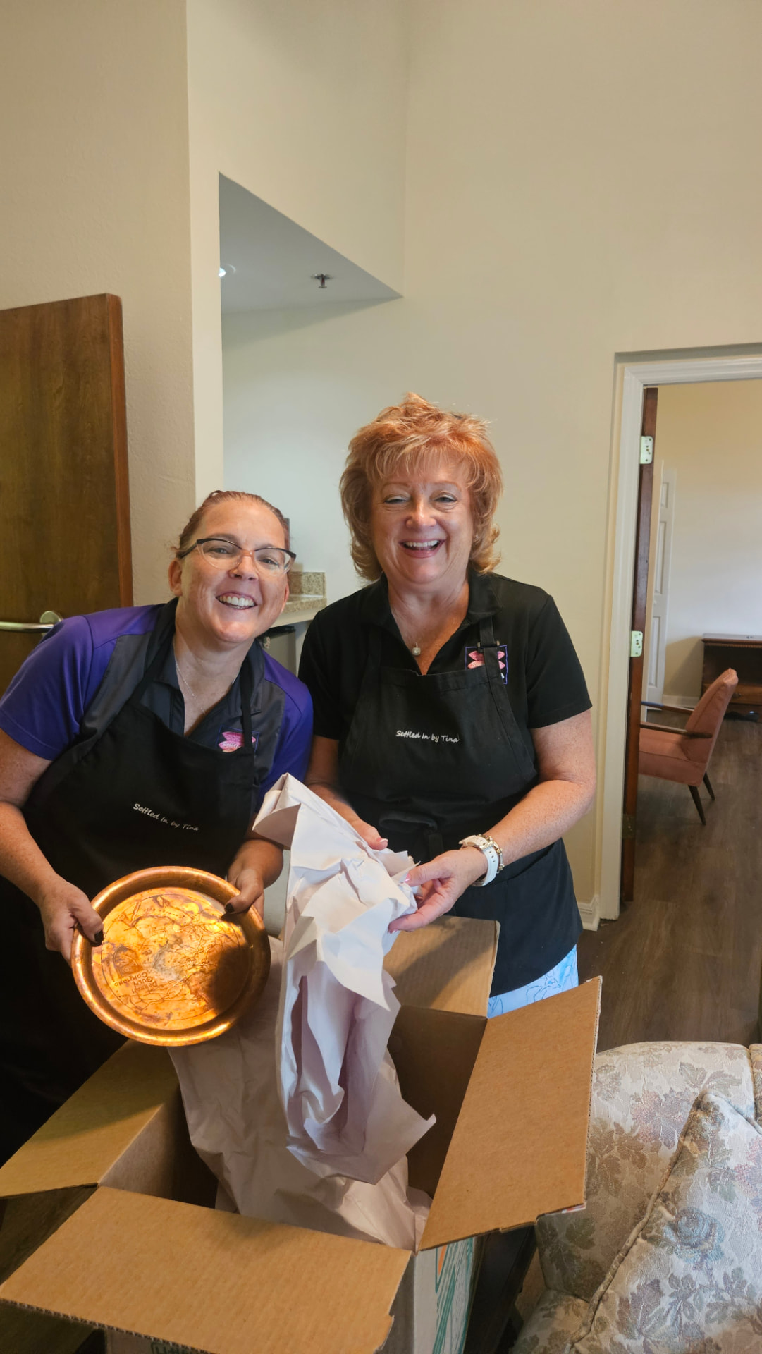 Tina and a Settled In by Tina team member unpacking a copper platter at a new residence