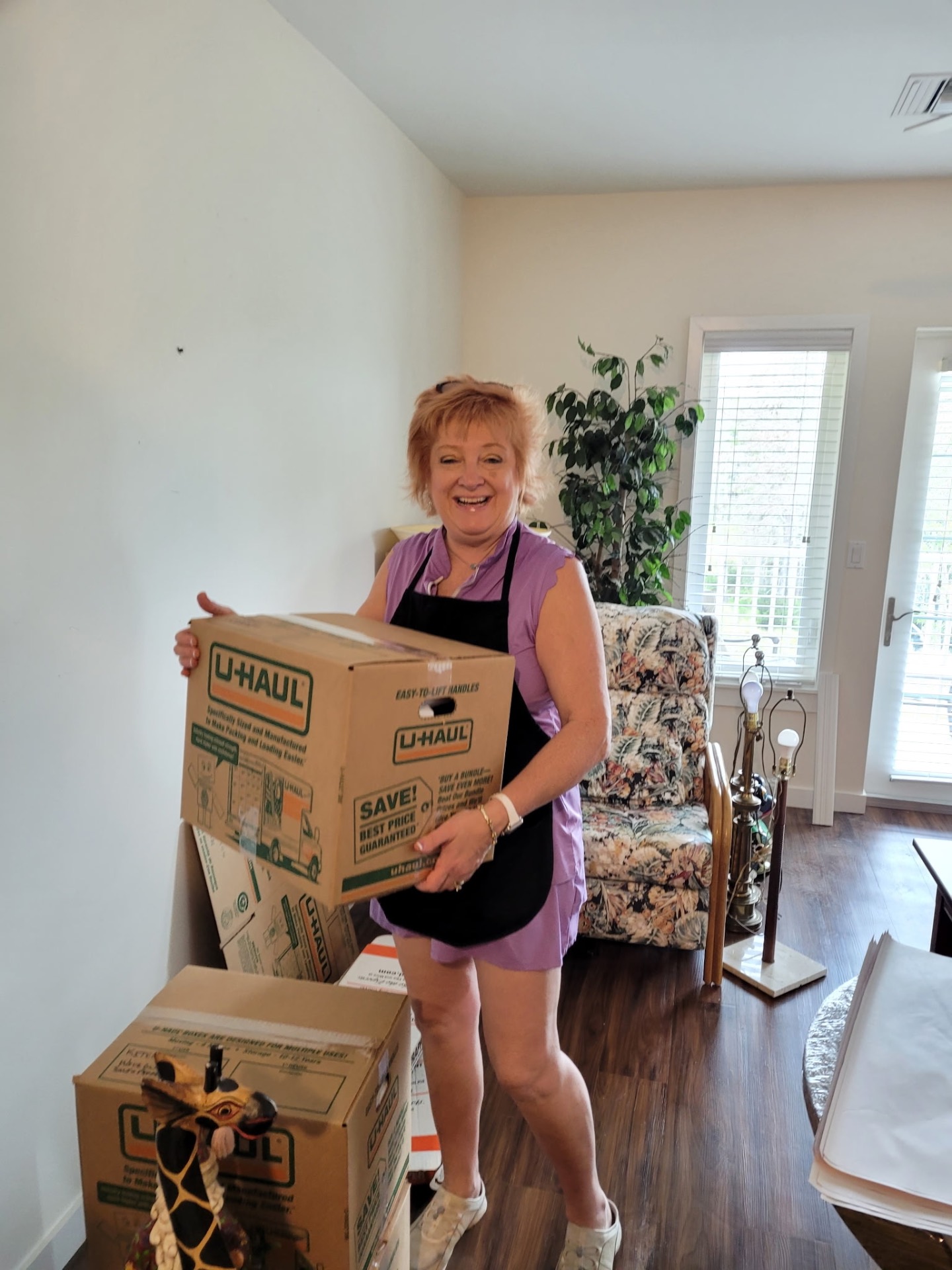 Tina packing a client's home with Settled In by Tina apron on