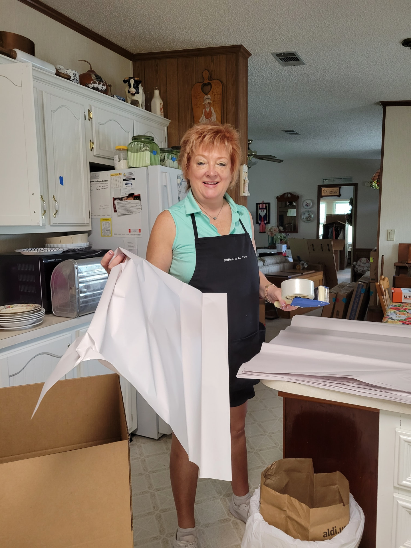Tina Leger wrapping and packing kitchen items during a senior move