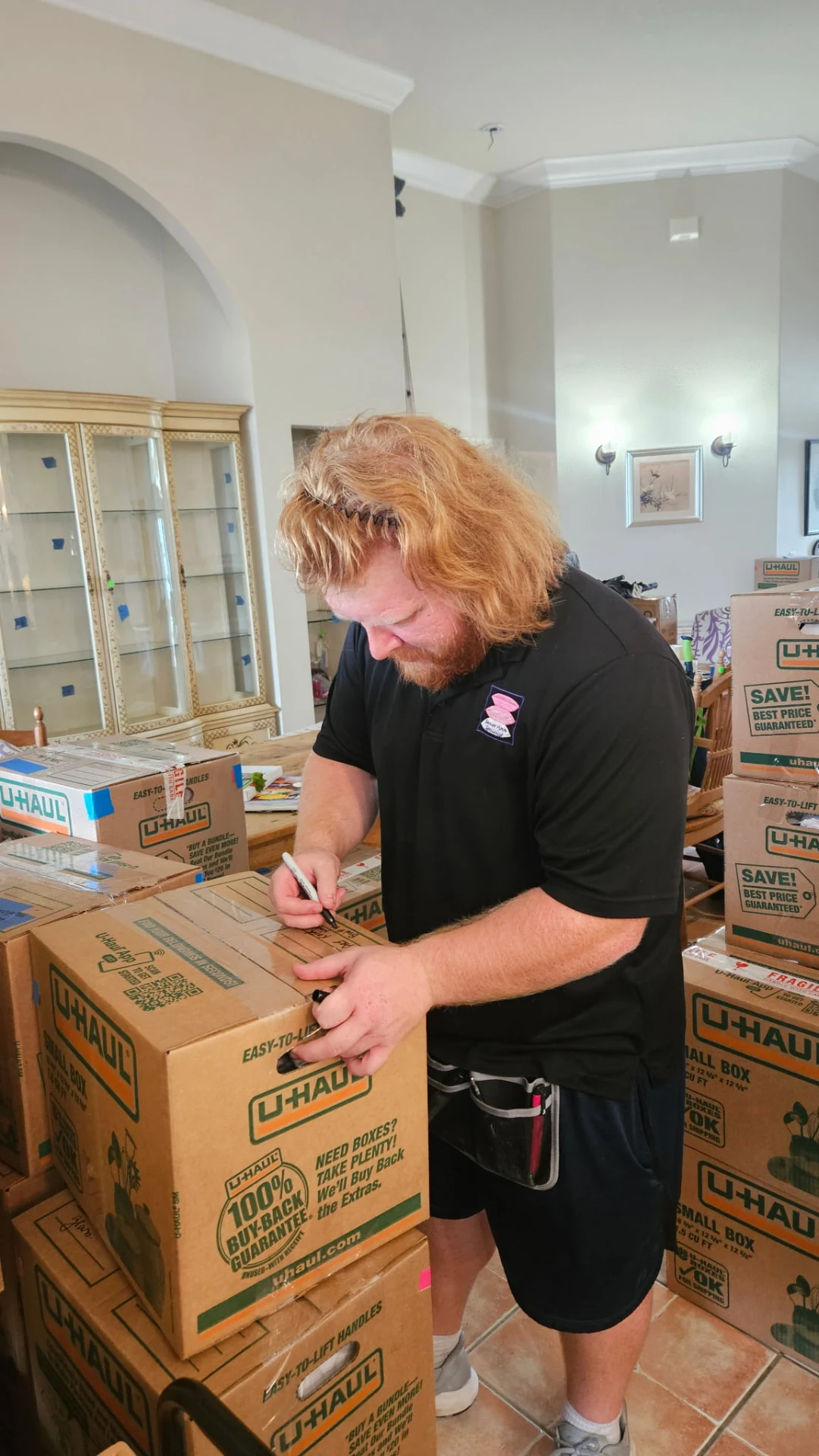Jackson carefully writing a label on a packed moving box