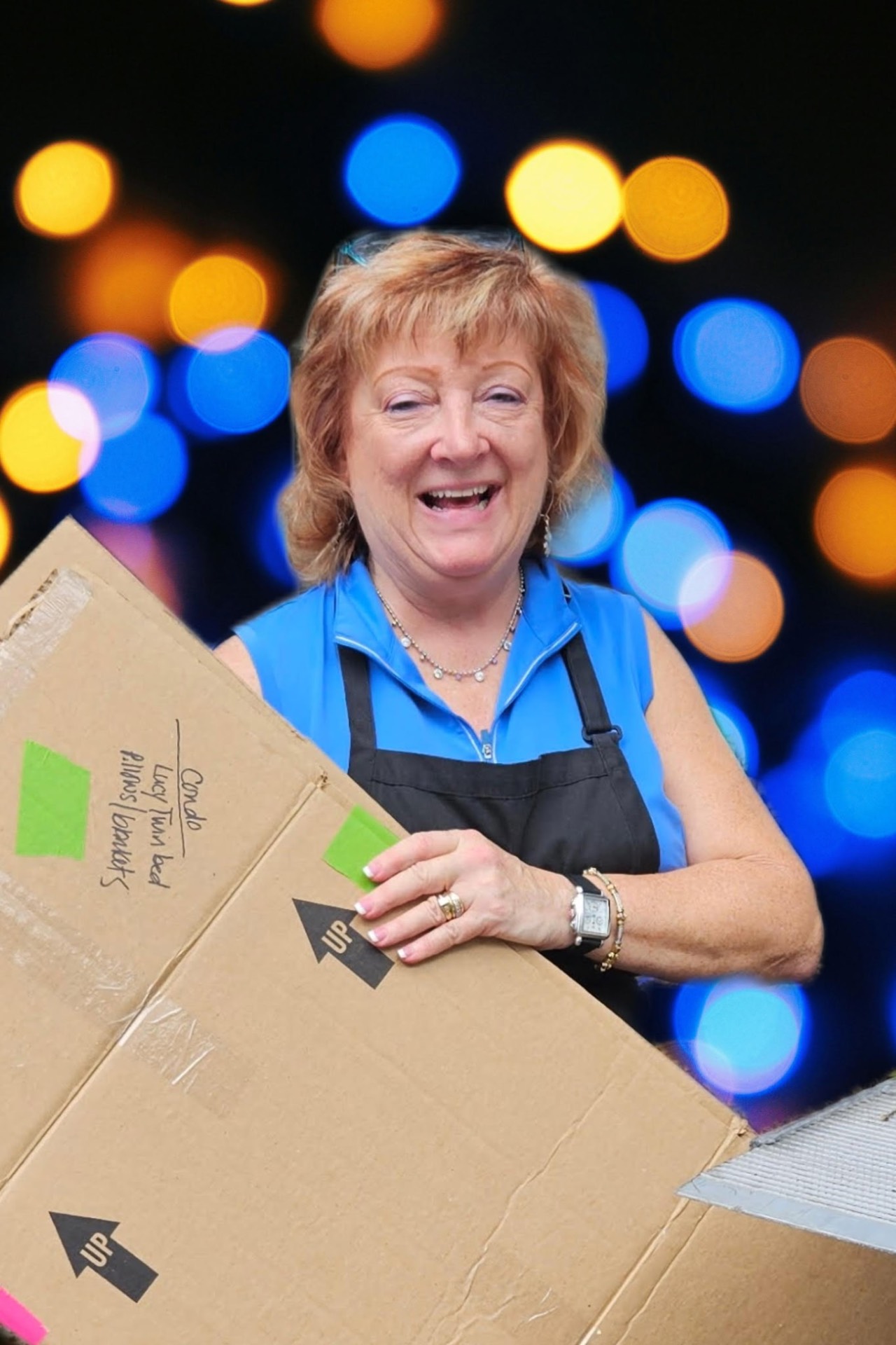 Tina smiling with a labeled moving box, ready to deliver to a client's new home