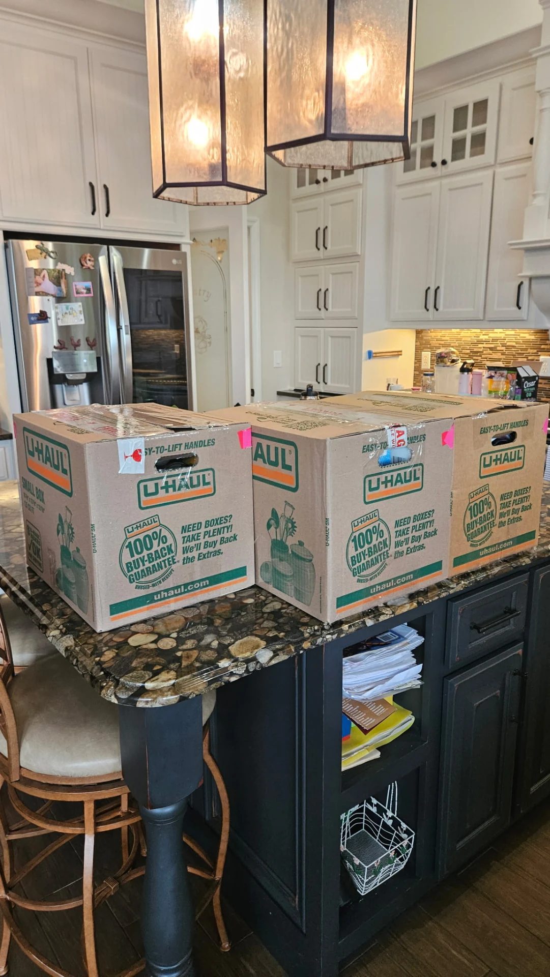 Sealed moving boxes arranged on a kitchen island with color-coded tape